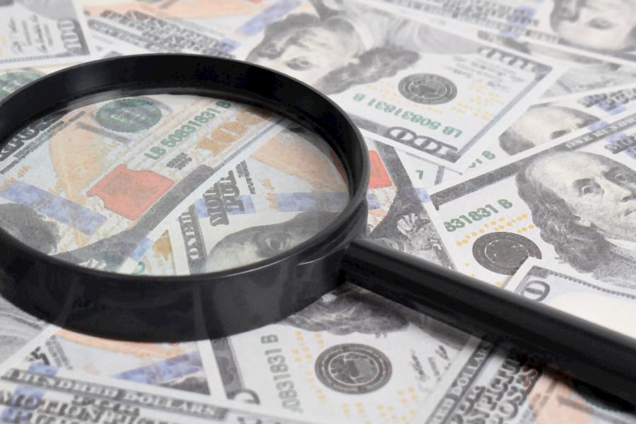 Money with magnifying glass